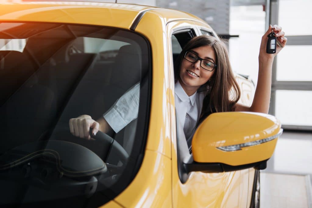 The woman driver smiling showing new car keys