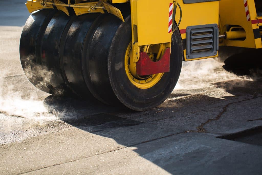 Road repairs. A road roller compacting asphalt.