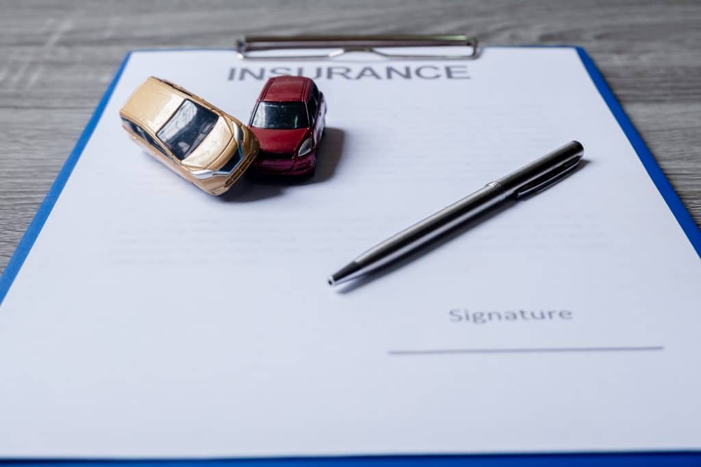 Car and pen on insurance documents. Car insurance concept